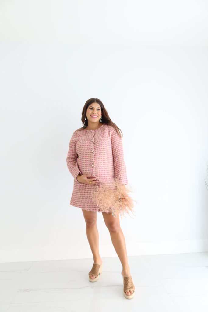 this polished pink tweed mini dress. This girl boss vibe is working for you, no doubt! This dress features a scoop neckline, scallop detailing, non-functional costume pearl buttons down the front and a back zipper closure. Model is wearing an x-small. 