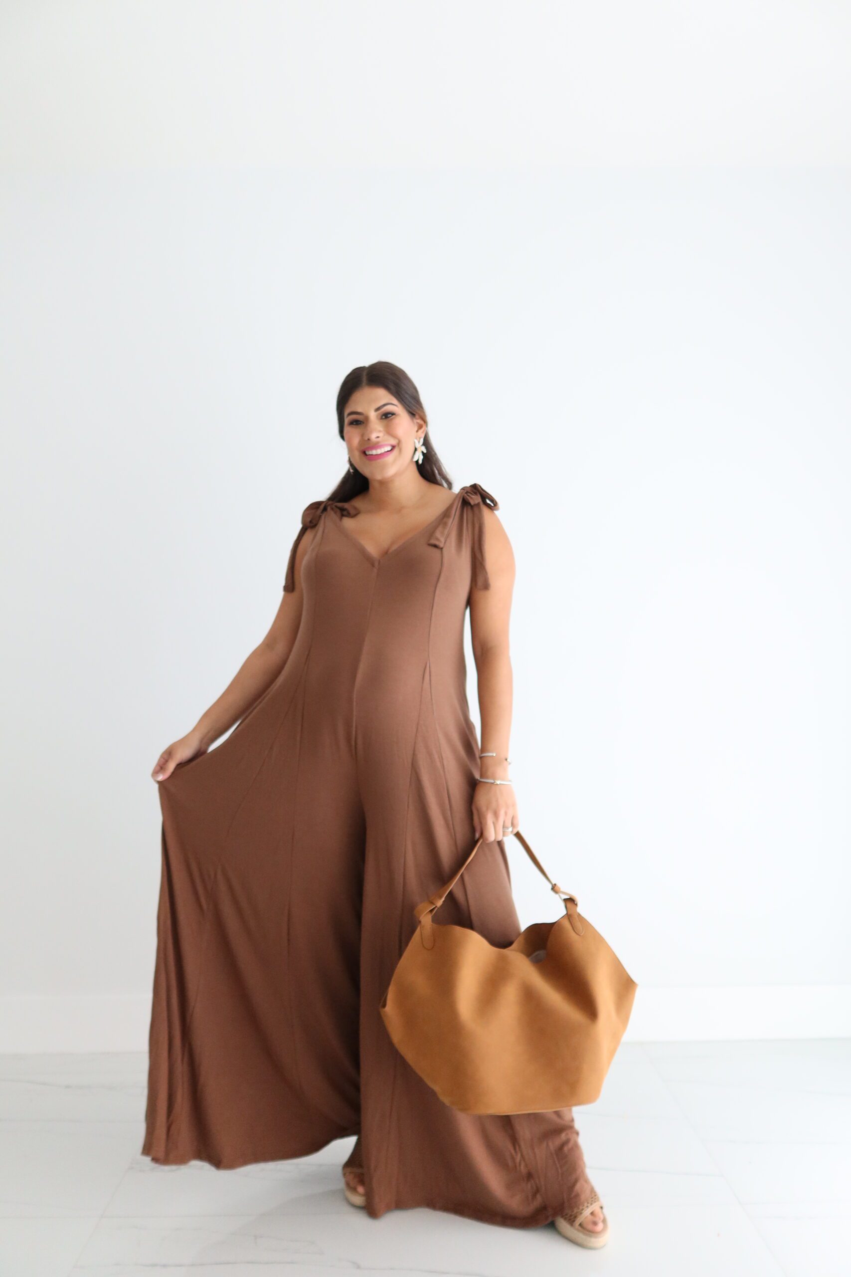 Lucky One Brown Jumpsuit! Perfect for a casual night out, you'll look and feel great as you strut your stuff in this comfy and fashionable must-have! So, don't hesitate - jump into the Lucky One and have the time of your life! This jumpsuit features a v-neckline, adjustable self-tie shoulder straps, two functional pockets, pleated detailing, and a flared leg.